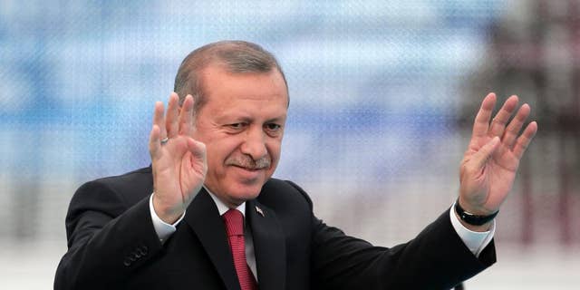 Turkey's President Recep Tayyip Erdogan waves to people gathered during a rally to commemorate the anniversary of the city's conquest by the Ottoman Turks, Istanbul, Turkey, Saturday, May 30, 2015. The Justice and Development Party (AKP), which has been ruling Turkey since 2002, is running in the upcoming general elections which are to be held on June 7, 2015, where approximately 56 million Turkish voters are eligible to cast their ballots to elect the 550 members of the Grand National Assembly. (AP Photo/Lefteris Pitarakis)