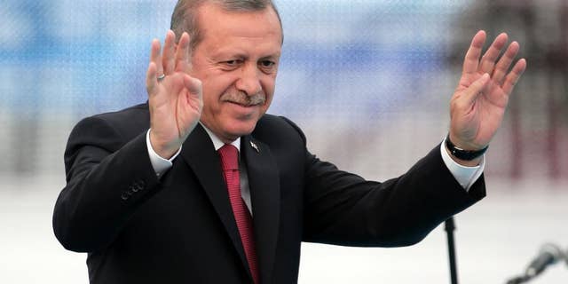 Turkey's President Recep Tayyip Erdogan waves to people gathered during a rally to commemorate the anniversary of the city's conquest by the Ottoman Turks, Istanbul, Turkey, Saturday, May 30, 2015. The Justice and Development Party (AKP), which has been ruling Turkey since 2002, is running in the upcoming general elections which are to be held on June 7, 2015, where approximately 56 million Turkish voters are eligible to cast their ballots to elect the 550 members of the Grand National Assembly. (AP Photo/Lefteris Pitarakis)