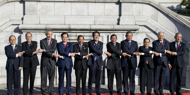 Japanese Prime Minister Shinzo Abe, center, and leaders of ASEAN countries join hands for a photo session of Japan-ASEAN commemorative summit at Akasaka State Guesthouse in Tokyo, Japan, Saturday, Dec. 14, 2013.
