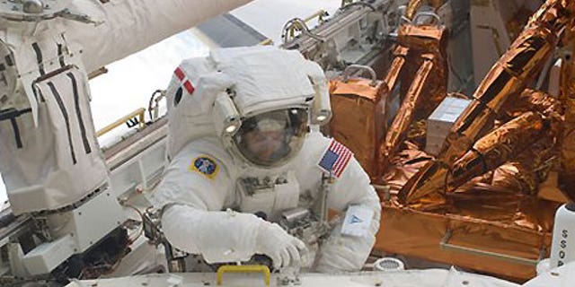 Astronaut Mike Massimino is photographed during extravehicular activity to refurbish and upgrade the Hubble Space Telescope.