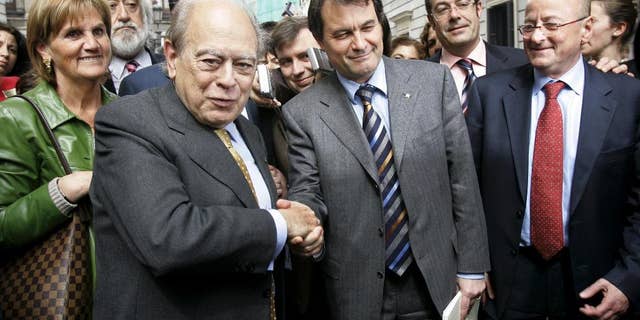 FILE - In this March 30, 2006 file photo, former president of the Catalonian autonomous government and member of the Convergence and Union Party (CiU), Jordi Pujol, left, shakes hands with Artur Mas, leader of CiU in Madrid, Spain. Spanish police on Tuesday Oct. 27, 2015 raided more than a dozen houses and offices of the family of Jordi Pujol, former longtime leader of Spain's Catalonia region, in a money-laundering and tax fraud probe. Pujol, 85, founded Catalonia's Convergence party that governs the economically powerful region. He was the region's president from 1980 to 2003 and is considered the father of the Catalan nationalist movement. His house was one of those searched Tuesday. (AP Photo/Bernat Armangue, File)