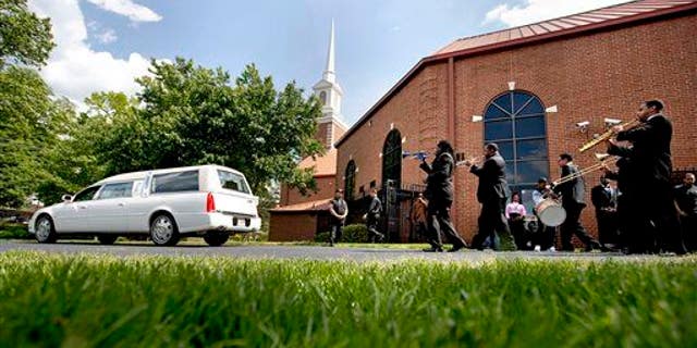A New Orleans style funeral procession follows the hearse carrying the casket of Chris Smith of the rap duo Kris Kross, after his funeral service, Thursday, May 9, 2013, in Atlanta. The 34-year-old Kelly was found dead May 1 of a suspected drug overdose.