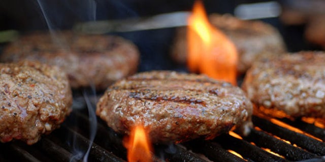 Hamburgers being flame broiled on the gas grill