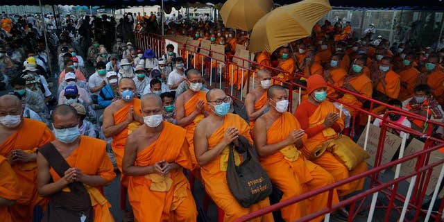 Buddhist monks of the Dhammakaya sect sit anticipating police raid outside the Dhammakaya sect temple in Pathum Thani, north of Bangkok, Thailand. Four Thai Buddhist monks have been sent to rehab after testing positive for methamphetamine, according to reports. 