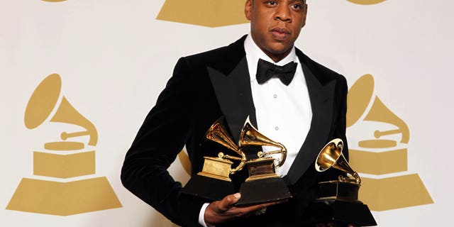 Jay-Z poses backstage with the awards for best rap/sung collaboration for "No Church in the Wild" and best rap performance for "N****s in Paris" at the 55th annual Grammy Awards on Sunday, Feb. 10, 2013, in Los Angeles.