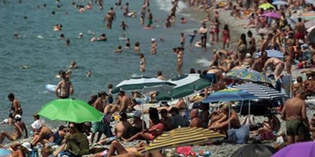 Holidaymakers enjoy the beach of the Promenade des Anglais on a hot summer day in Nice July 23, 2013. REUTERS/Eric Gaillard