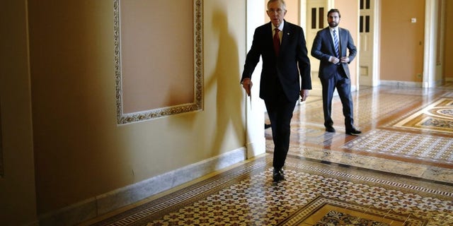 Senate Majority Leader Harry Reid walks to address reporters after the weekly Republican caucus luncheon at the U.S. Capitol in Washington March 11, 2014. (REUTERS/Jonathan Ernst)