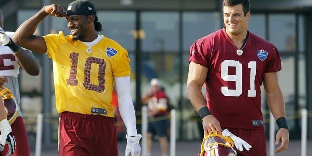 Aug 6, 2014; Richmond, VA, USA; Washington Redskins quarterback Robert Griffin III (10) and outside linebacker Ryan Kerrigan (91) walk onto the field prior to joint practice with the New England Patriots on day twelve at the Bon Secours Washington Redskins Training Center. Mandatory Credit: Geoff Burke-USA TODAY Sports