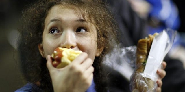 Ayana Kleckner, 15, eats an apple as she waits to take an eye exam at the Remote Area Medical (RAM) health clinic in Inglewood, California August 11, 2009. REUTERS/Mario Anzuoni