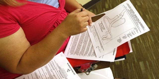 Carolyn Dawson, bariatric surgery patient looks at a diagram of her procedure at her surgeon Dr. Michael Snyder's office in Denver five days before her operation August 25, 2010. REUTERS/Rick Wilking