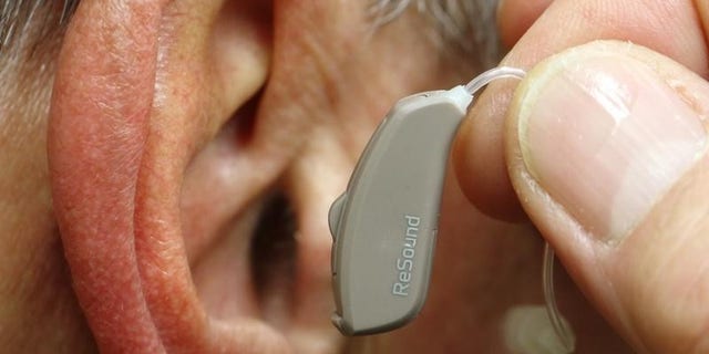 An employee of GN, the world's fourth largest maker of hearing aids, demonstrates the use of ReSound LiNX in Vienna November 22, 2013. REUTERS/Heinz-Peter Bader