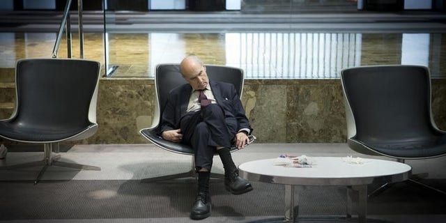 A businessman takes a mid-day nap in the lobby of a midtown hotel in the Manhattan borough of New York August 1, 2014. REUTERS/Carlo Allegri