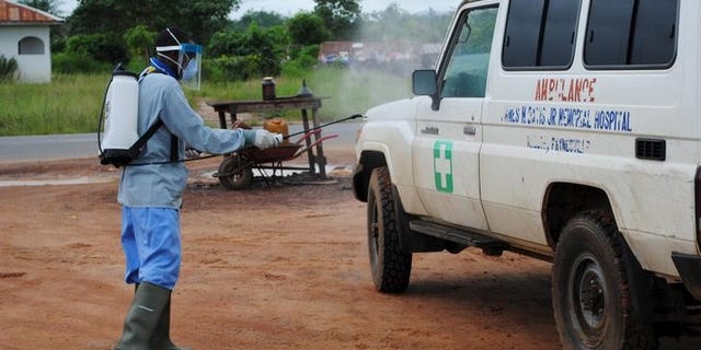 A health worker sprays disinfectant on an ambulance in Nedowein, Liberia, July 15, 2015. REUTERS/James Giahyue