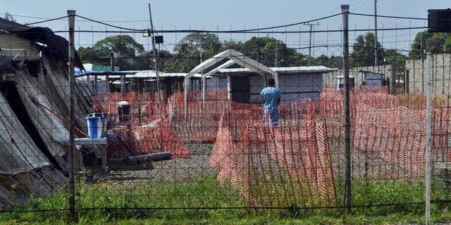 A health worker stands in the Ebola virus treatment center where three people are currently being treated in Paynesville, Liberia, November 23, 2015.  REUTERS/James Giahyue