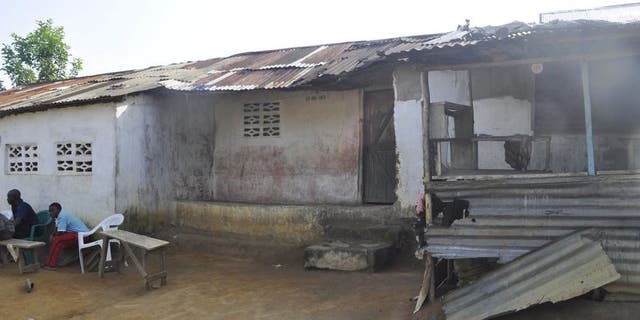 File photo of men sitting in front of a house where Ebola victim Nathan Gbotoe lived, in Paynesville, Liberia, November 24, 2015. REUTERS/James Giahyue
