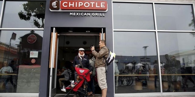 A man snaps a photograph at the entrance to Chipotle Mexican Grill in San Francisco, California July 21, 2015. REUTERS/Robert Galbraith