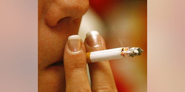 A woman smokes a cigarette in a restaurant in Munich, December 31, 2007. REUTERS/Alexandra Beier