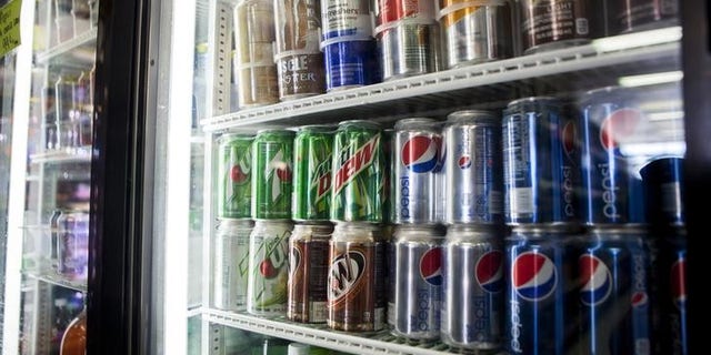 Cans of soda are displayed in a case at Kwik Stops Liquor in San Diego, California February 13, 2014. REUTERS/Sam Hodgson/Files