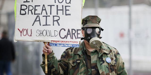 Brian Seligman holds a sign to protest a gas leak in the Porter Ranch area of Los Angeles before a meeting of the California Air Quality Management District in Granada Hills, California, Jan. 9, 2016.
