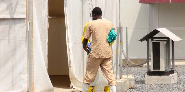 A health worker enters a tent in an Ebola virus treatment center in Conakry, Guinea, November 17, 2015. REUTERS/Saliou Samb