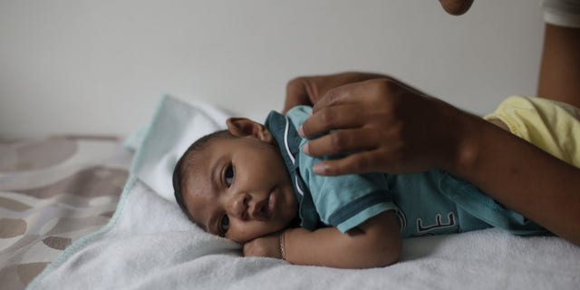 Mariam Araujo, plays with Lucas, her second child and born with microcephaly as they wait for a physiotherapy session in Pedro I hospital in Campina Grande
