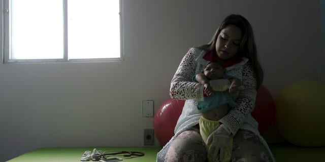 Physiotherapist Leal does exercises with Lucas, 4-months old, who is Miriam Araujo's second child and born with microcephaly in Pedro I hospital in Campina Grande