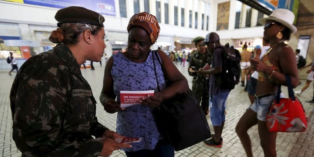 A Brazilian Army soldier distributes pamphlets with information to combat the Aedes aegypti mosquito during the National Day of Mobilization Zika Zero at Central train station in Rio de Janeiro
