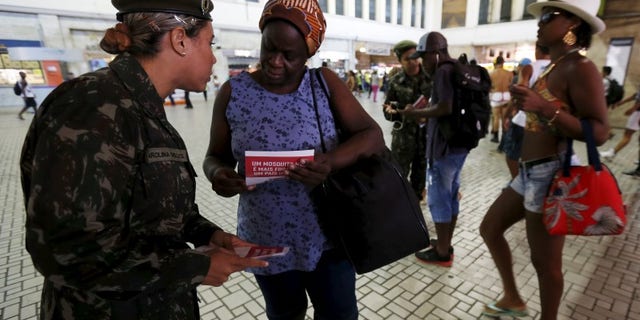 A Brazilian Army soldier distributes pamphlets with information to combat the Aedes aegypti mosquito during the National Day of Mobilization Zika Zero at Central train station in Rio de Janeiro