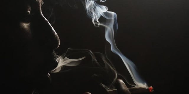 A heroin addict smokes heroin in Lamu