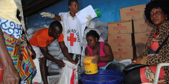 Red Cross workers distribute food at a World Food Programme storage center in Monrovia