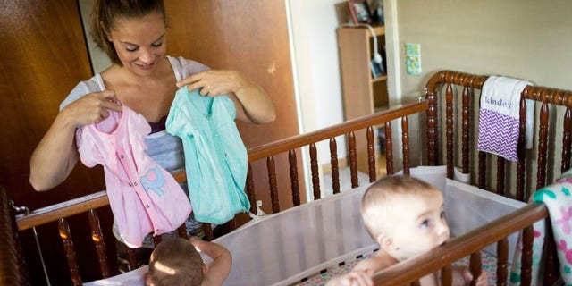 Heather Padgett dresses her daughters Kinsley and Kiley at her home in Cincinnati