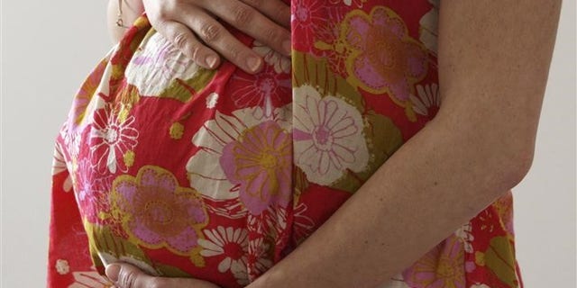 A woman holds her stomach at the last stages of her pregnancy in Bordeaux