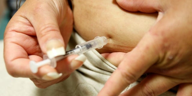 Diabetic Khachatoorian injects herself with insulin at the J.W.C.H. safety-net clinic in downtown Los Angeles