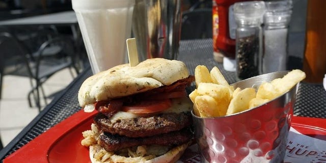 A meal of a "Monster"-sized A.1. Peppercorn burger, Bottomless Steak Fries, and Monster Salted Caramel Milkshake is seen at a Red Robin restaurant in Foxboro