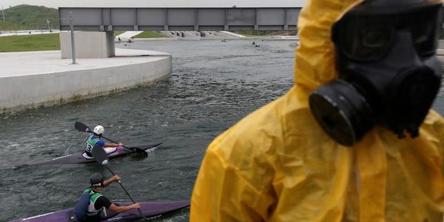 Athletes attend a training session at 2016 Rio Olympics Games' Canoe Slalom Circuit as Brazilian Army soldiers take part in a simulation of decontamination of multiple victims during a a training in Rio de Janeiro