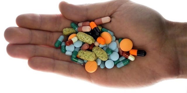 A person holds pharmaceutical tablets and capsules in illustration picture in Ljubljana