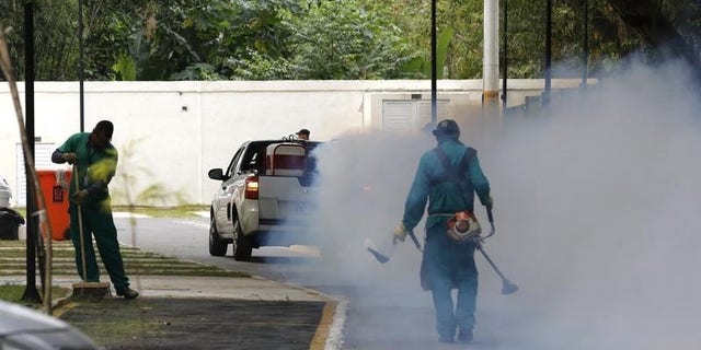 A truck sprays insecticide around Olympic media accomodations in Rio de Janeiro