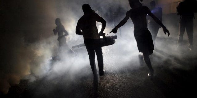 A worker of the Ministry of Public Health and Population fumigates in the street against mosquito breeding to prevent diseases such as malaria, dengue and Zika, during a fumigation campaign in Port-au-Prince, Haiti