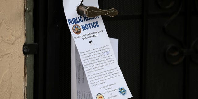 County vector control leave information on door handles as they hand-spraying a neighborhood for adult Aedes mosquitoes after a travel-related case of Zika was confirmed in this the area of San Diego
