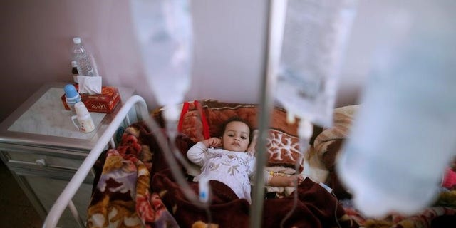 A girl lies on a bed at a cholera treatment center in Sanaa, Yemen