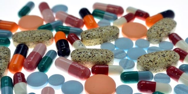 Pharmaceutical tablets and capsules are arranged on table in photo illustration