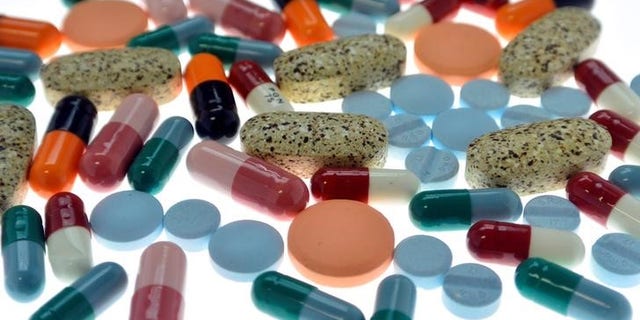 Pharmaceutical tablets and capsules are arranged on table in photo illustration