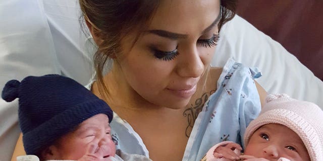 This Jan. 1, 2016 photo provided by Kaiser Permanente San Diego shows Maribel Valencia holds her newborn twins at the San Diego Kaiser Permanente Zion Medical Center in San Diego. Jaelyn, right, and Luis Salgado, who were born just minutes apart, but in different years. Jaelyn was born in the last minute of New Year's Eve 2015 and Luis in the first few minute of New Year's Day 2016. (Kaiser Permanente San Diego via AP)