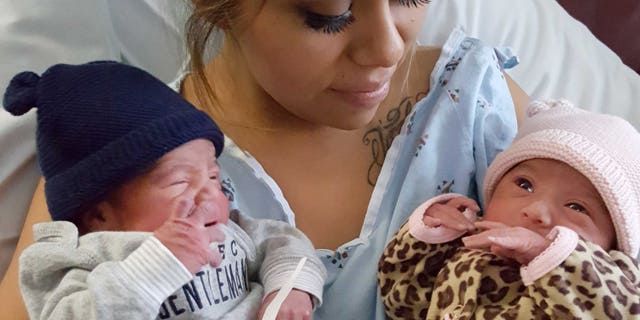 This Jan. 1, 2016 photo provided by Kaiser Permanente San Diego shows Maribel Valencia holds her newborn twins at the San Diego Kaiser Permanente Zion Medical Center in San Diego. Jaelyn, right, and Luis Salgado, who were born just minutes apart, but in different years. Jaelyn was born in the last minute of New Year's Eve 2015 and Luis in the first few minute of New Year's Day 2016. (Kaiser Permanente San Diego via AP)
