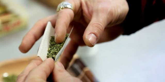 A participant practices rolling a joint at the Cannabis Carnivalus 4/20 event in Seattle