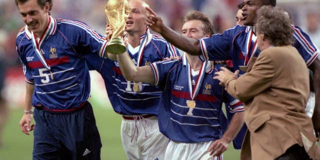 FILE - In this July 12, 1998 filer, Didier Deschamps, center, celebrates on the pitch with the world cup after defeating Brazil in the World Cup Final, in Stade de France, in Saint-Denis, Paris. (AP Photo/ Eric Draper, File)