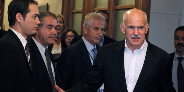 Nov. 8, 2011: Greek Prime Minister George Papandreou, right, gestures as he arrives for a cabinet meeting at the parliament in Athens.
