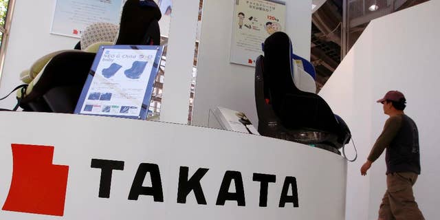 FILE - In this Wednesday, May 4, 2016 file photo, a visitor walks past child seats, manufactured by Takata Corp., displayed at an automaker's showroom in Tokyo. A criminal complaint has been filed in Japan about a Takata air bag causing injuries during a crash, the first such case in this nation related to an unfolding massive recall. Takata Corp. said Wednesday, June 8, 2016, it was fully cooperating with the investigation of the accident, in which a woman in the front passenger seat of a Nissan X-Trail sport-utility vehicle was injured.(AP Photo/Shizuo Kambayashi, File)
