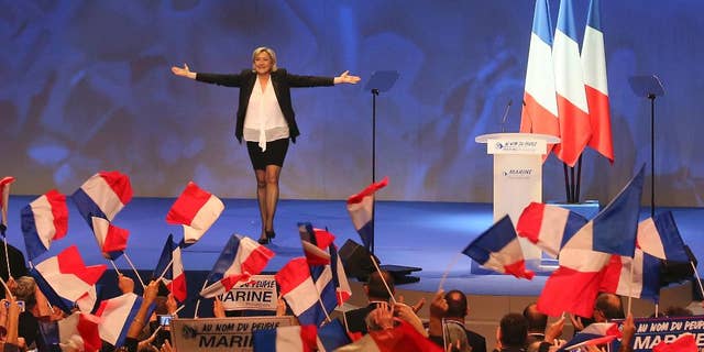FILE - In this Feb. 26, 2017 file photo, French far-right leader presidential candidate Marine Le Pen gestures at the start of a meeting in Nantes, western France. Marine Le Pen, whose passion for politics and far-right values were forged in the cradle, is making her second bid for the French presidency, hoping this time to break through the ceiling of fear that stopped her father from winning in 2002. (AP Photo/David Vincent, File)