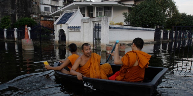 Nov. 6, 2011: Thai Buddhist monks navigate a small boat along flooded streets in Bangkok, Thailand.